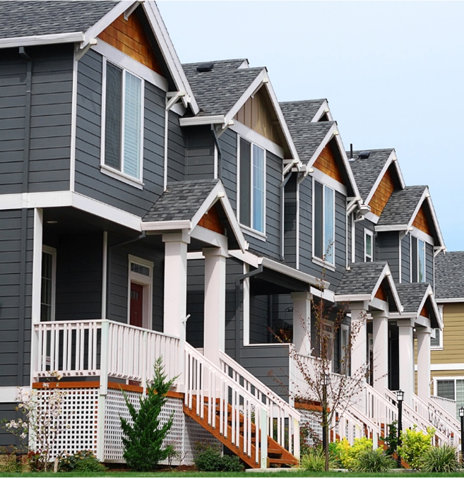 Row of gray townhouses with white trim.